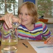 Eine Schülerin untersucht die Brechung in Luft, Wasser und Öl.