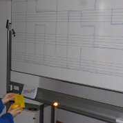 Mit einem Spiegel wird der Weg durch ein aufgemaltes Labyrinth beleuchtet.