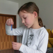 Eine Schülerin testet die Stärke eines Magneten.